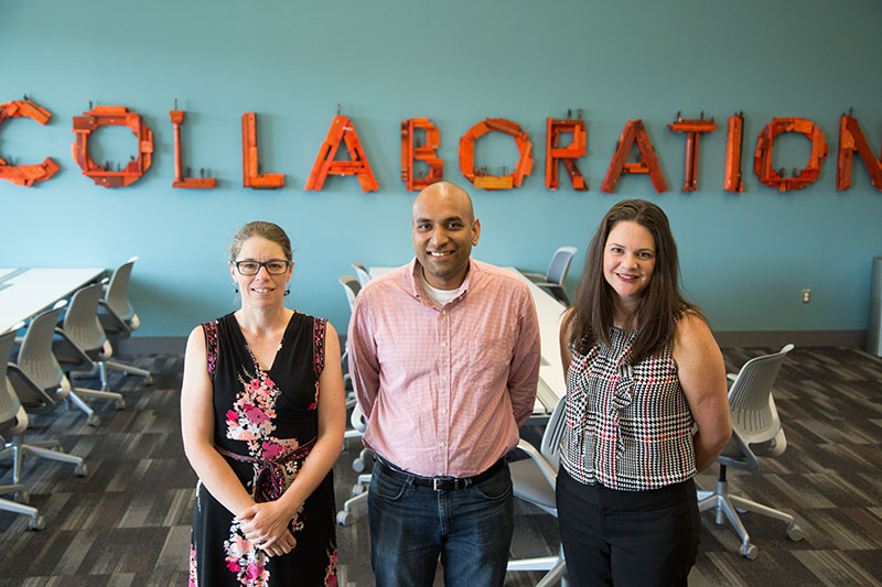 SPA faculty in front of collaboration sign.