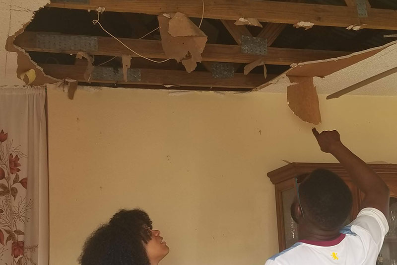 Students inspect a damaged ceiling. 