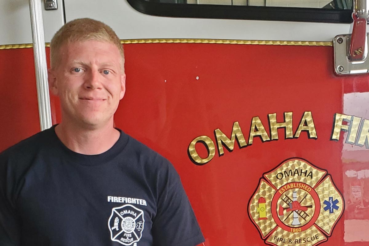 Gregorgy Eckstrom, a UNO student, stands by an Omaha fire truck.