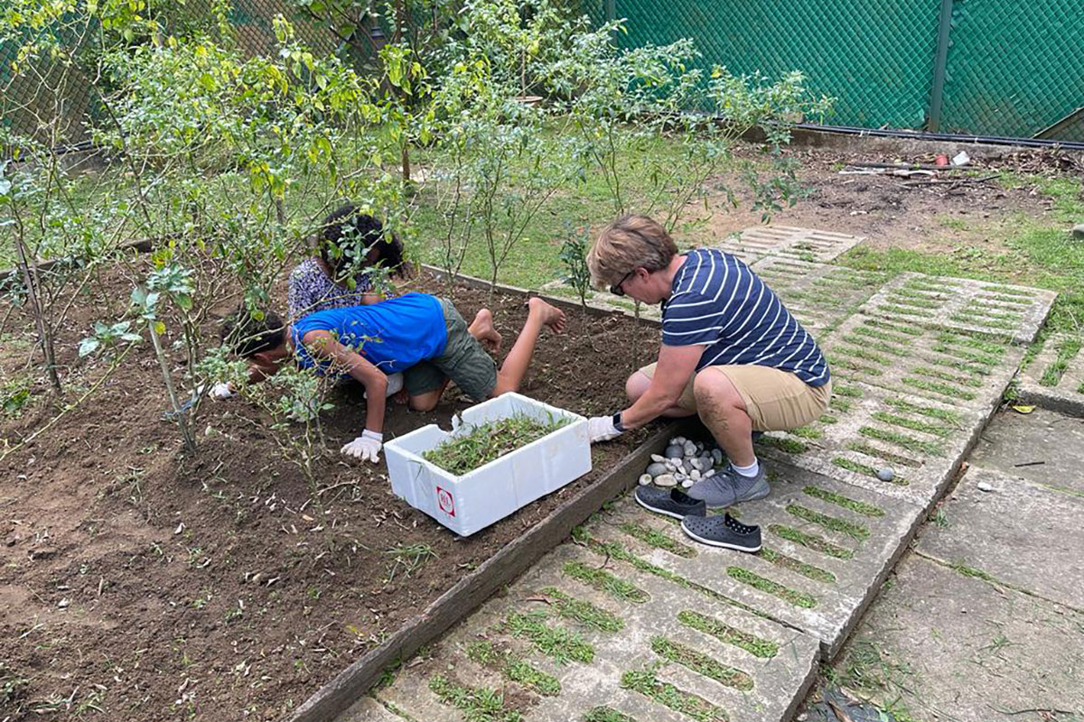 Anne Hobbs and children working in a Singapore eco-garden.