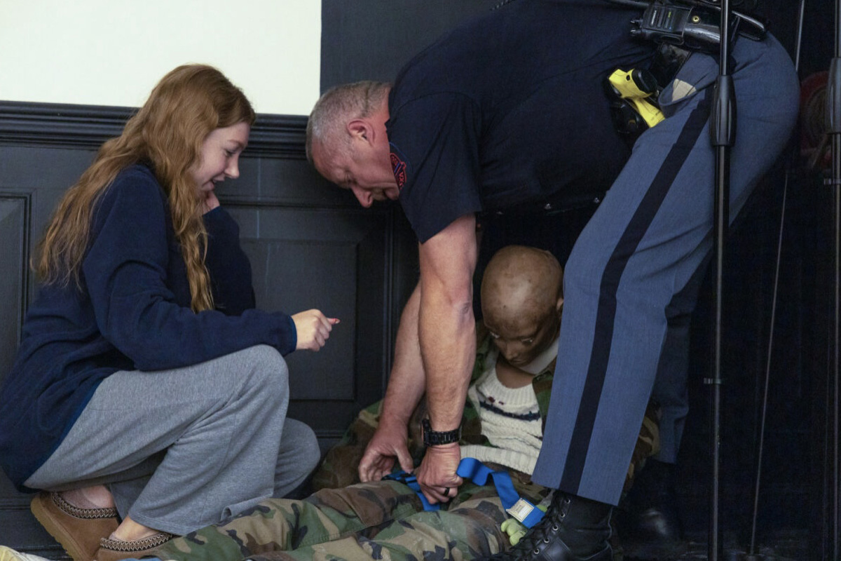 Police officer demonstrating how to aid a victim