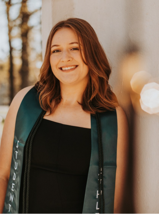 Caitlyn Jordan standing against a wall.