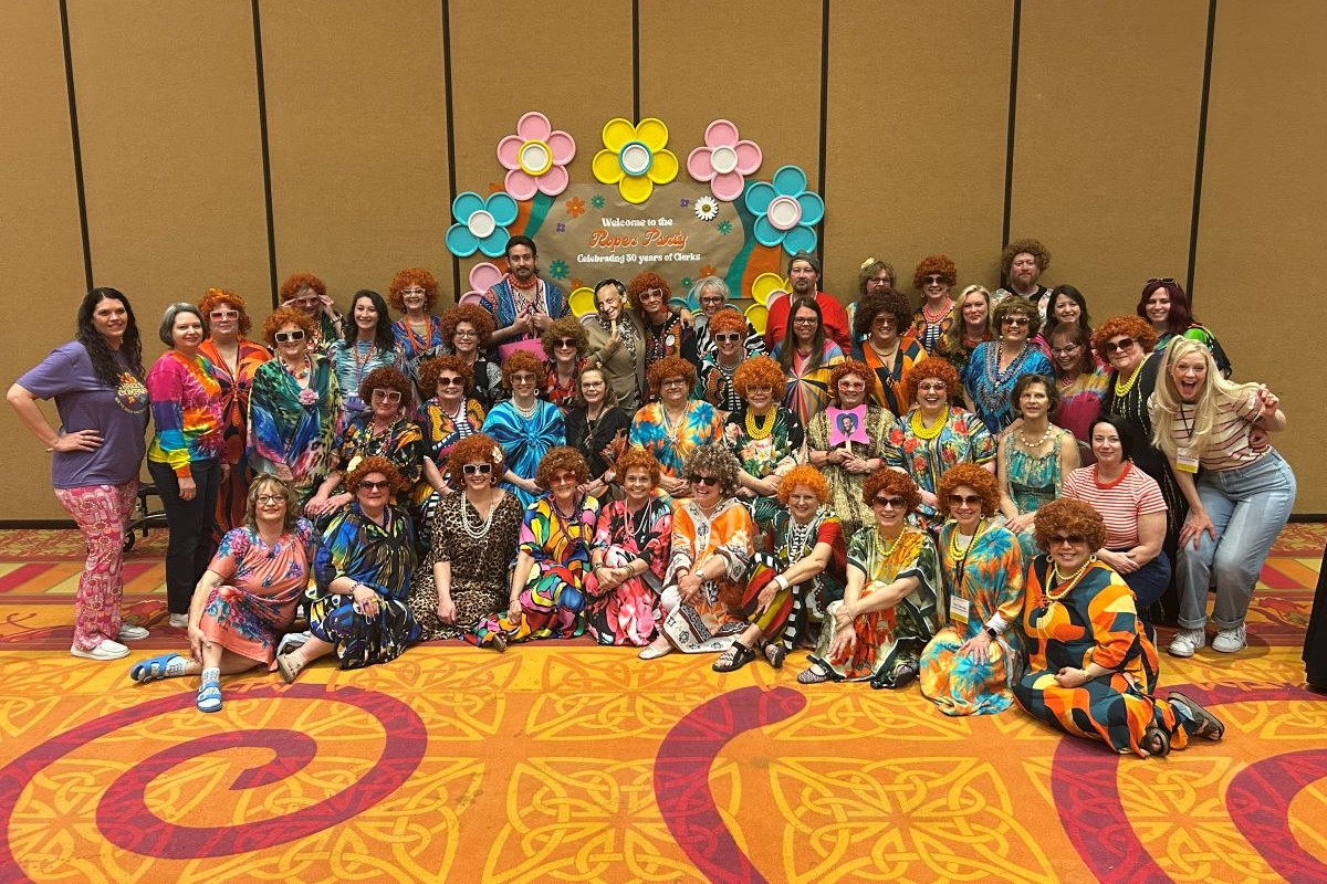 Group of clerks posed, dressed as characters from Three's Company.