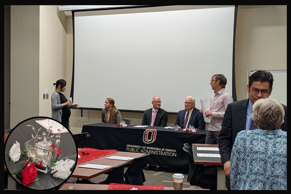 Panel of three people sitting in front of a conference room table.
