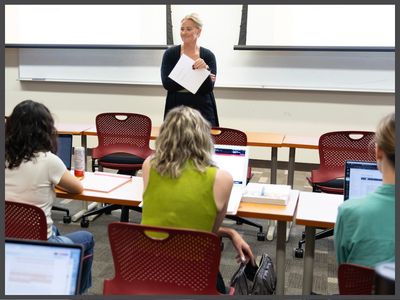 Instructor standing in front of a classroom of students.