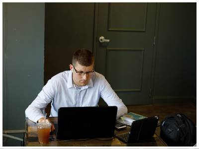 Man working on a laptop sitting at a desk.