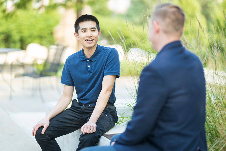 two people sitting outside and talking