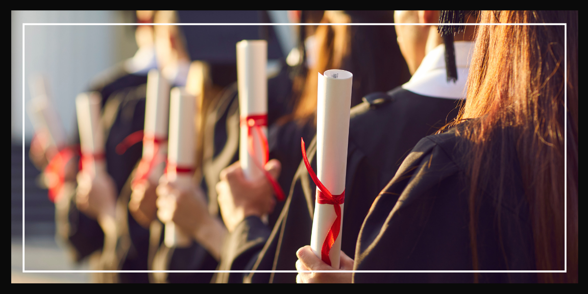 multiple students holding rolled up diplomas.