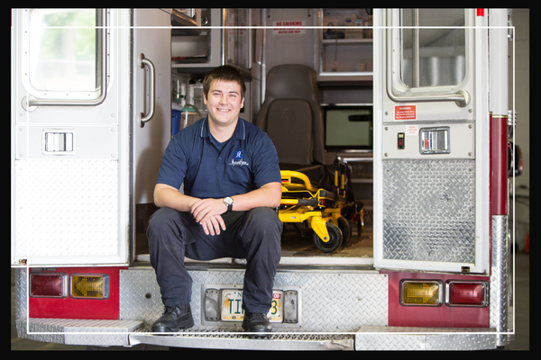 student sitting on the back end of a firetruck.