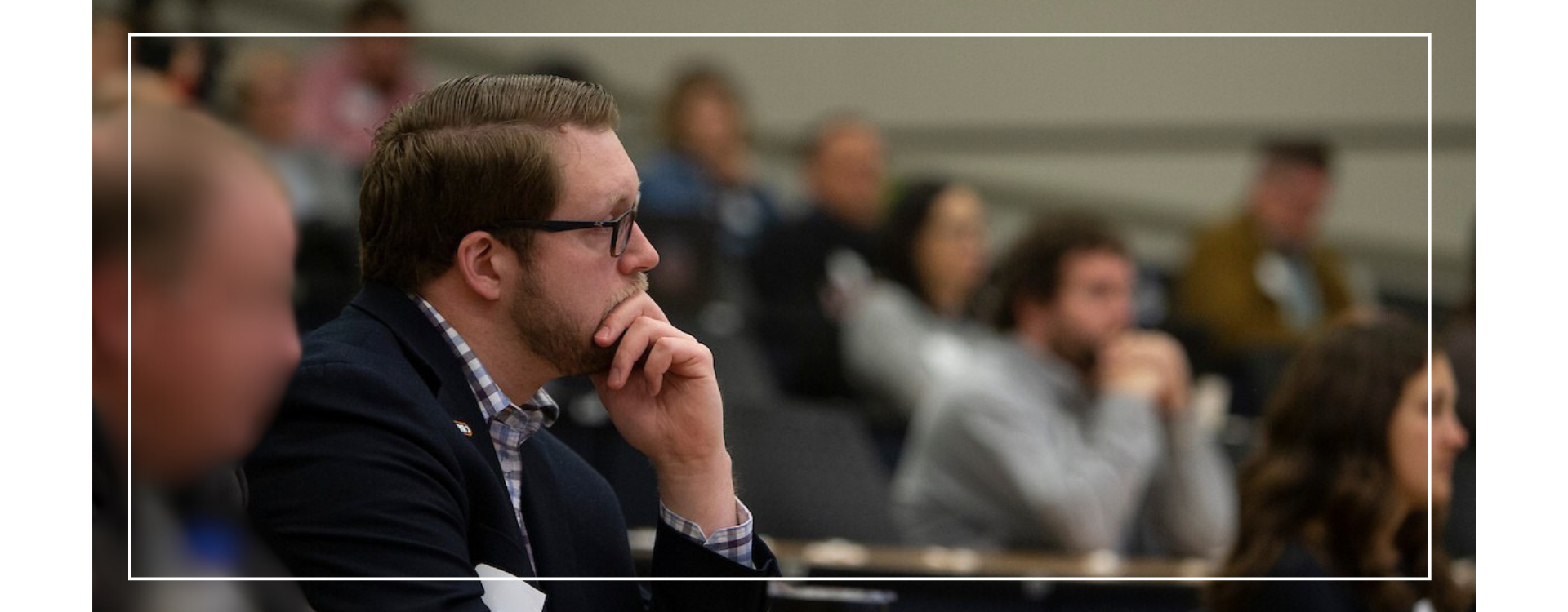 adult students sitting in a large lecture hall.
