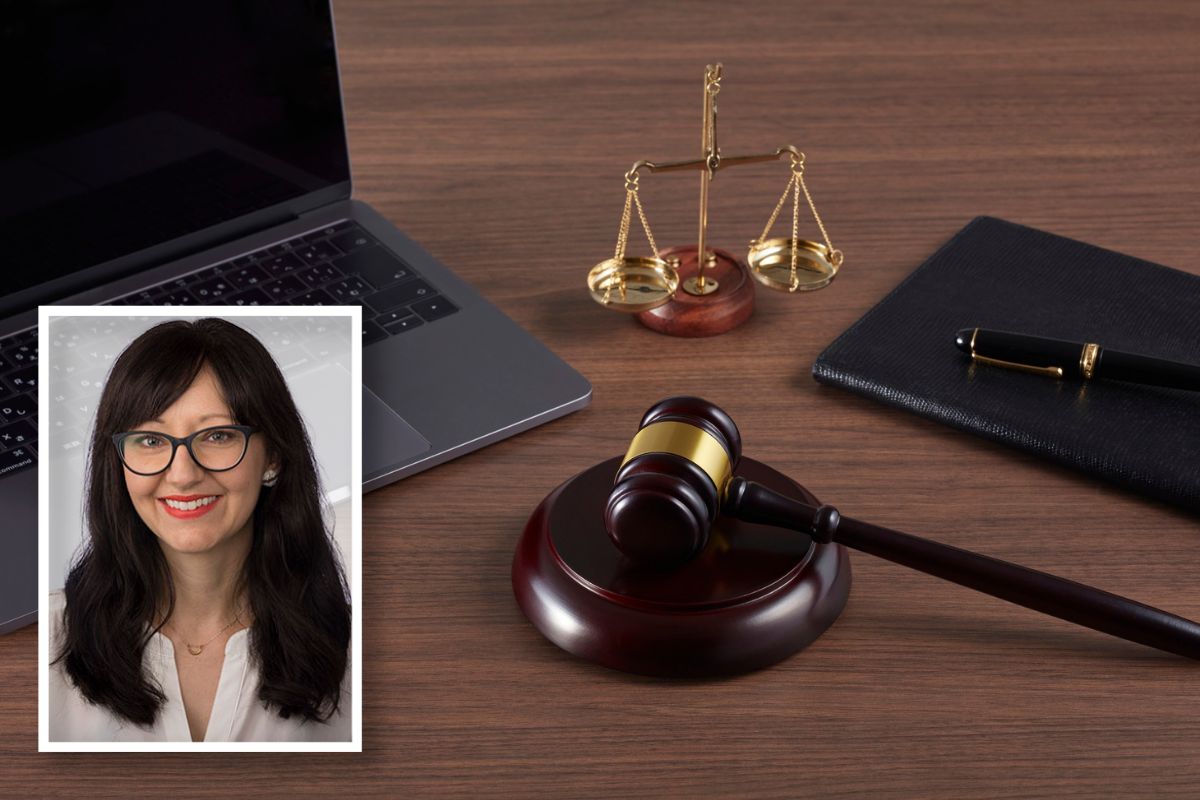 Laptop sitting on a desk with a mini scale and a gavel.