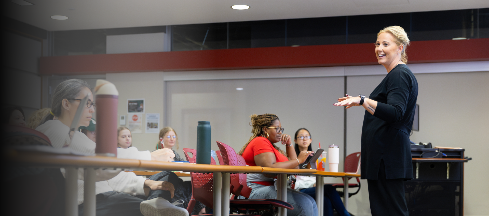 Instructor standing in front of a classroom of students.