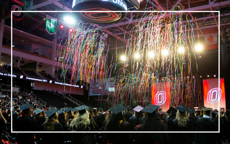 Commencement ceremony with streamers falling from the ceiling.