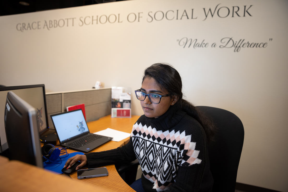 Student sitting at an office desk working on a computer.