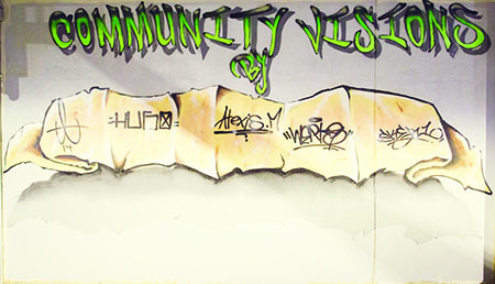 A graffiti-style mural reading “Community Visions” in green letters above a scroll-like banner covered in black handwritten tags and signatures.