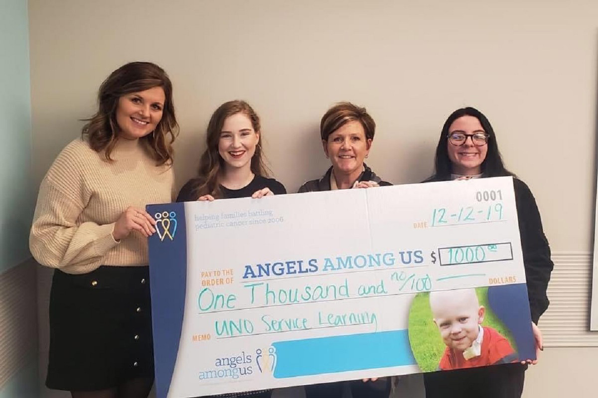 UNO Students from Casey Riesberg’s Fall 2019 Fundamentals of Public Speaking course present a $1,000 grant check to Angels Among Us.