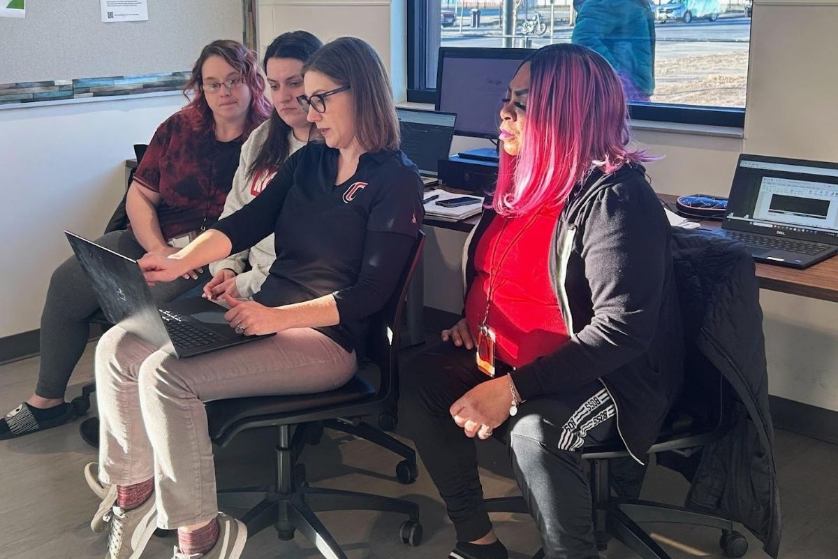 A UNO faculty member collaborates with community participants on computer training during the Work-Learn program, which helps adults gain technology skills for workforce reentry.