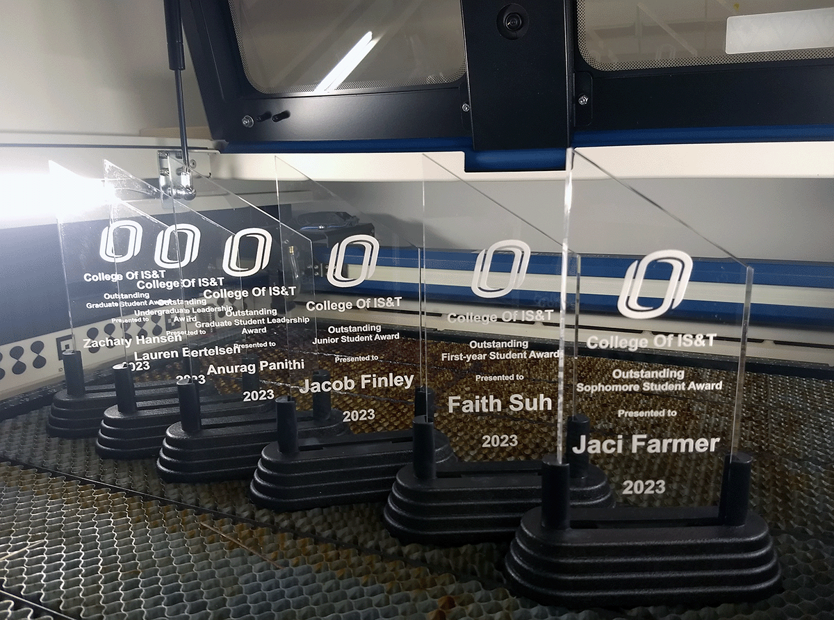 Acrylic awards sitting on table of laser cutting machine.