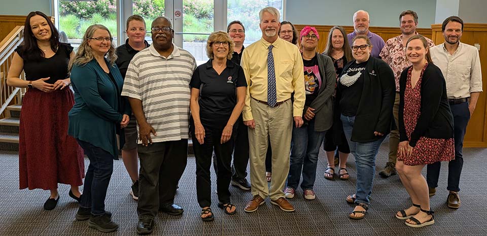 A diverse group of people smiling at the camera.