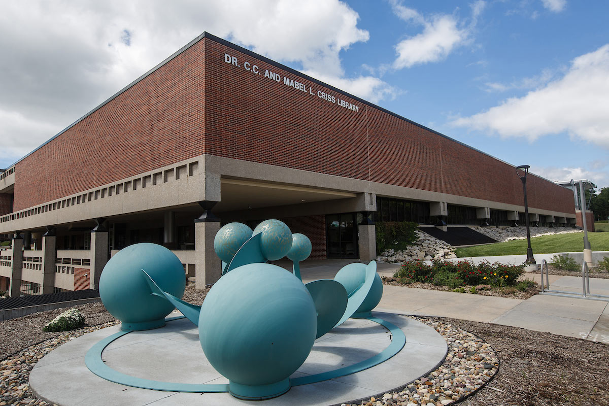 the criss library building in the background with blue sculpted spheres in the foreground