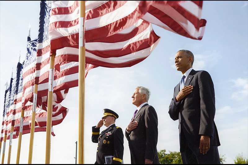 Men saluting under U.S. flags