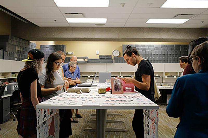 People looking at historical material on tables in Archives and Special Collections. 