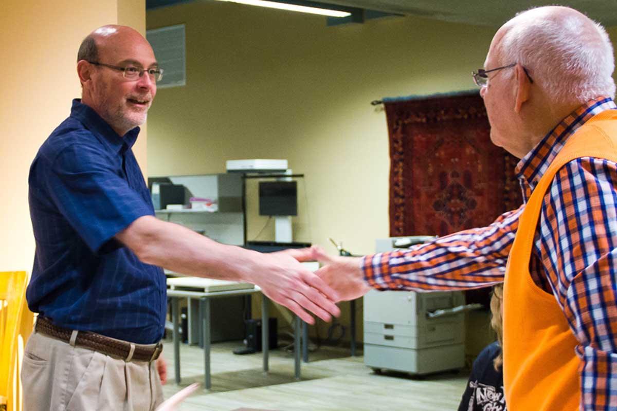 Les Valentine greets a UNO alumnus at a Library event