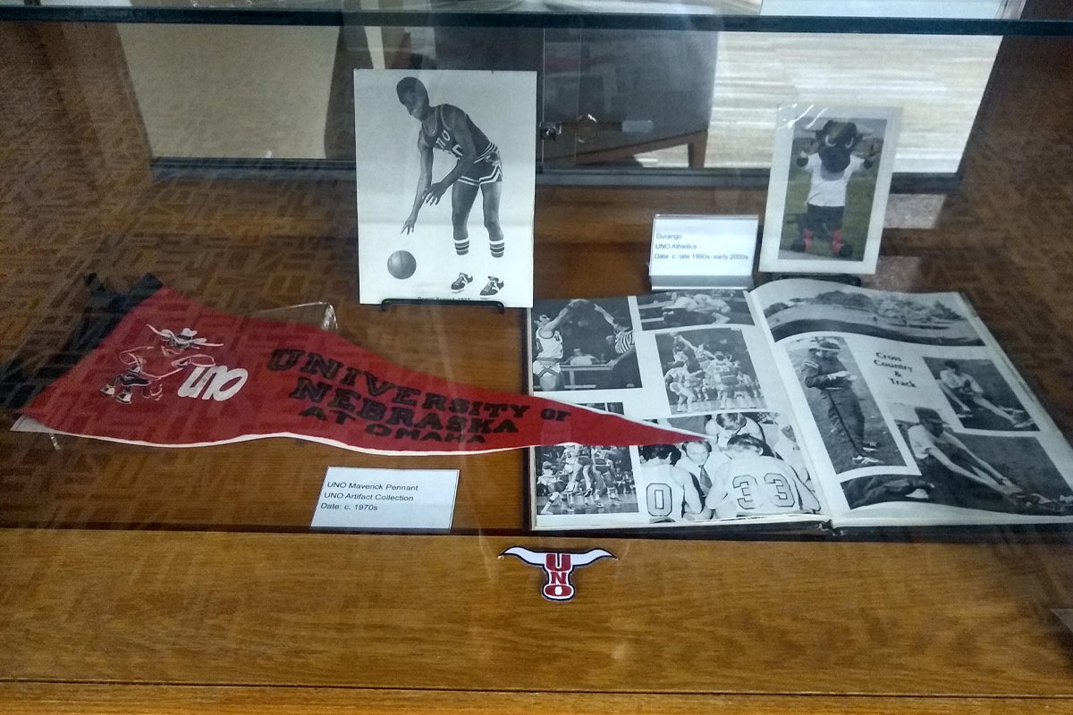 glass and wood display cases with books, photos, and sports memorabilia