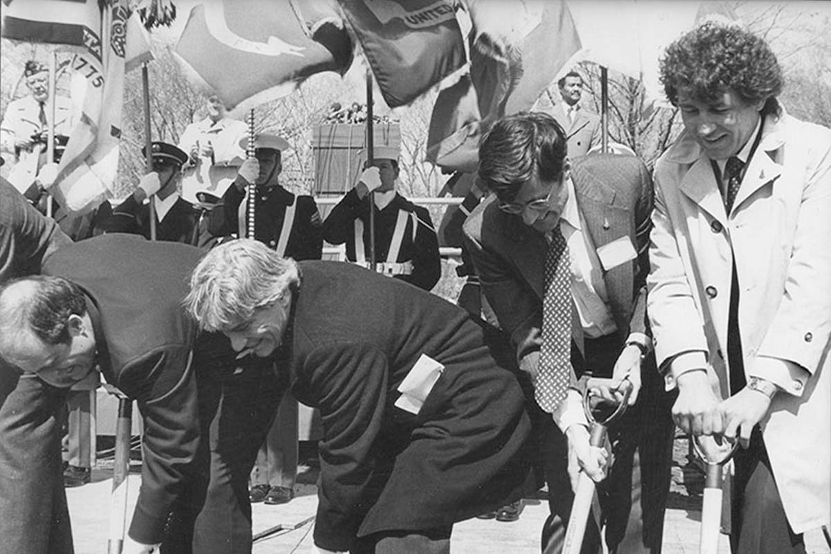 black and white photo of men shoveling for the groundbreaking of a memorial 