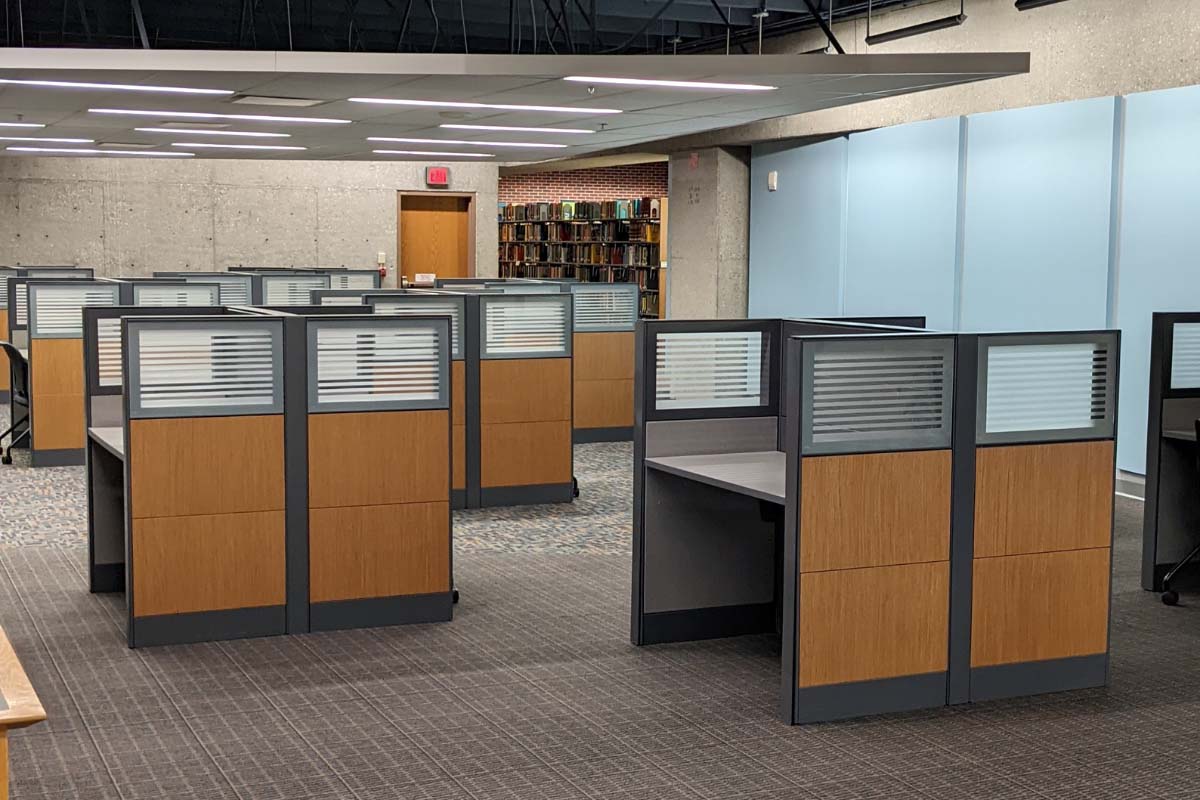 empty single study carrels near a light blue wall 