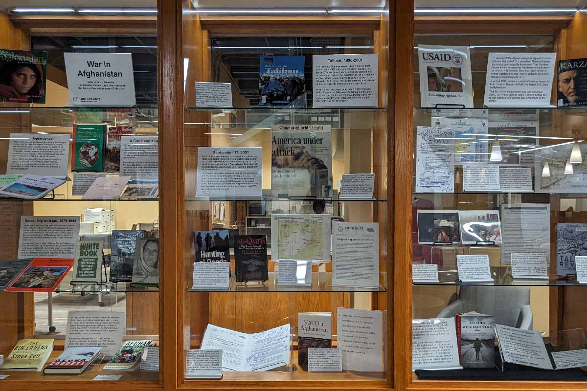 built in wooden shelves with books, papers, and other objects about the war in afghanistan