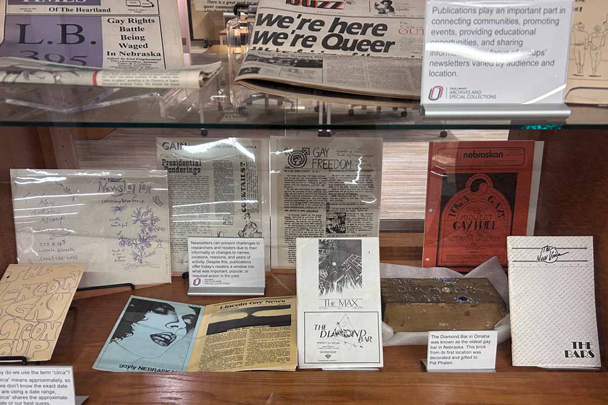 Display case of historical LGBTQ+ documents and a brick from the Diamond Bar in Omaha.