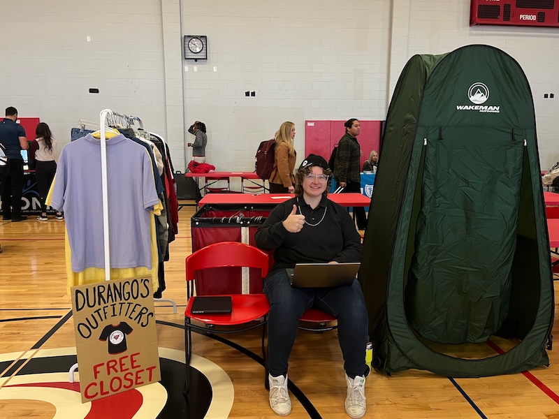 student sitting in chair at a tabling event in H&K