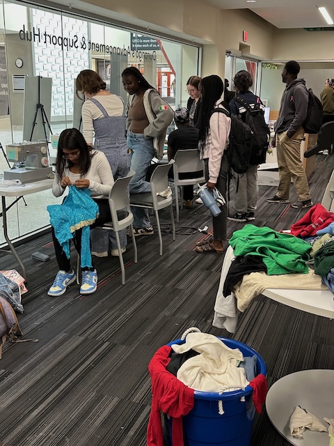 lots of students in the dash office, working on sewing machines or hand sewing
