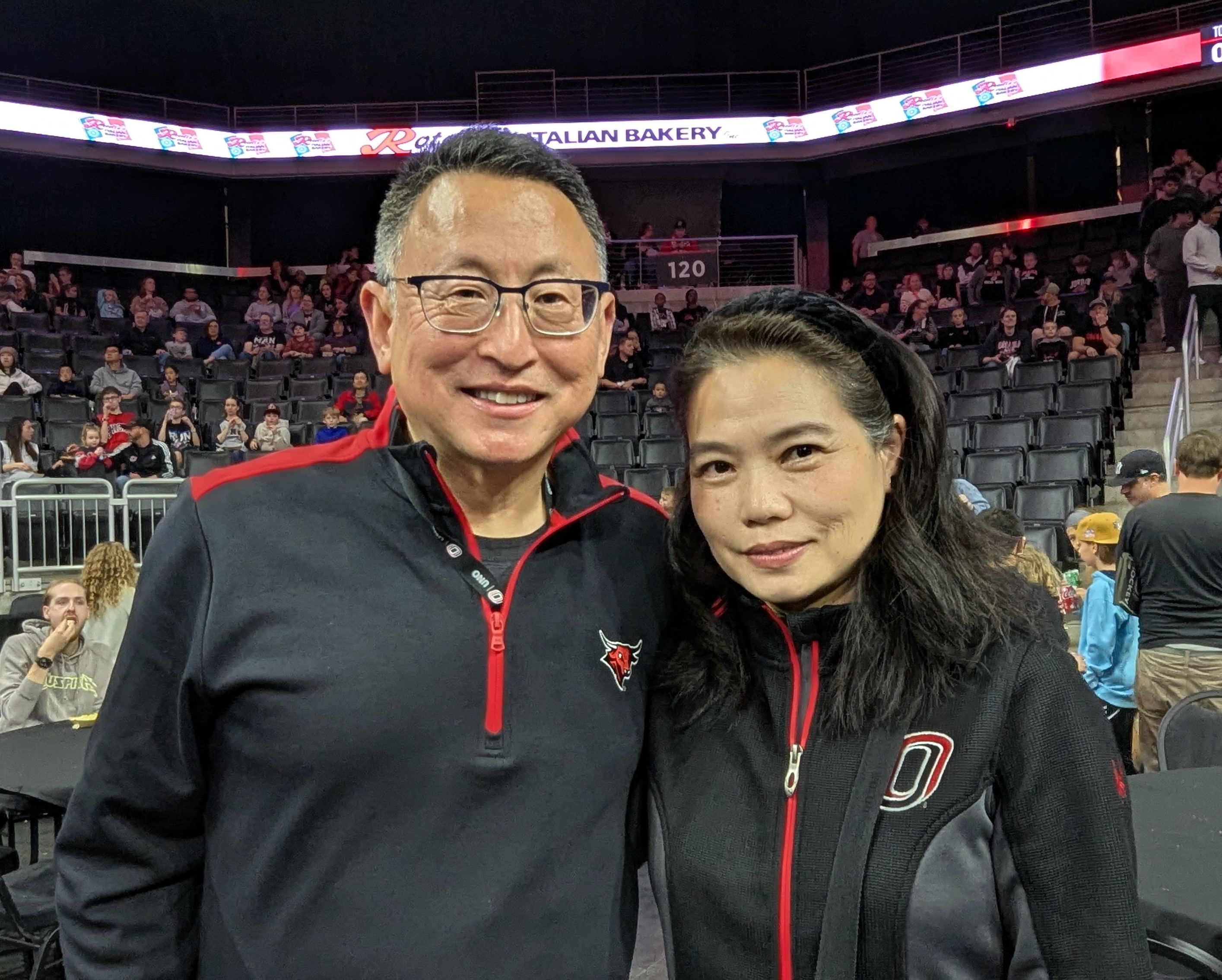 Phil He and Ling Ren smiling together in the Baxter Arena