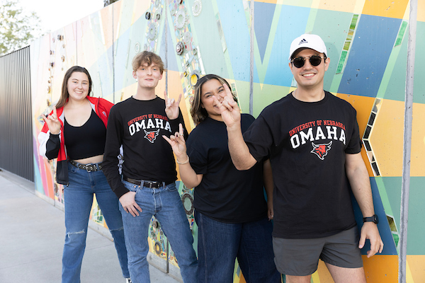 students dressed in UNO gear pose for a picture Coneflower Creamery in the Millwork District of Omaha