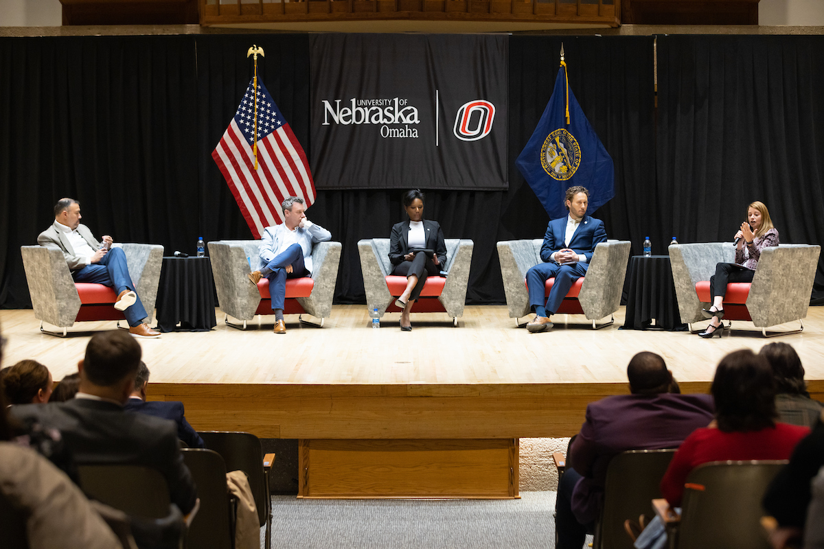 Panelists of the Future of Work Symposium sitting in chairs while listening intently to one of the presenters