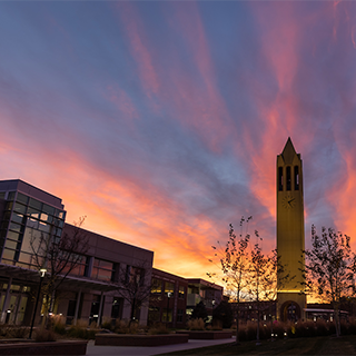 UNO Dodge Campus at sunset. The Henningson Memorial Campanile is center image with burnt orange clouds in the background.