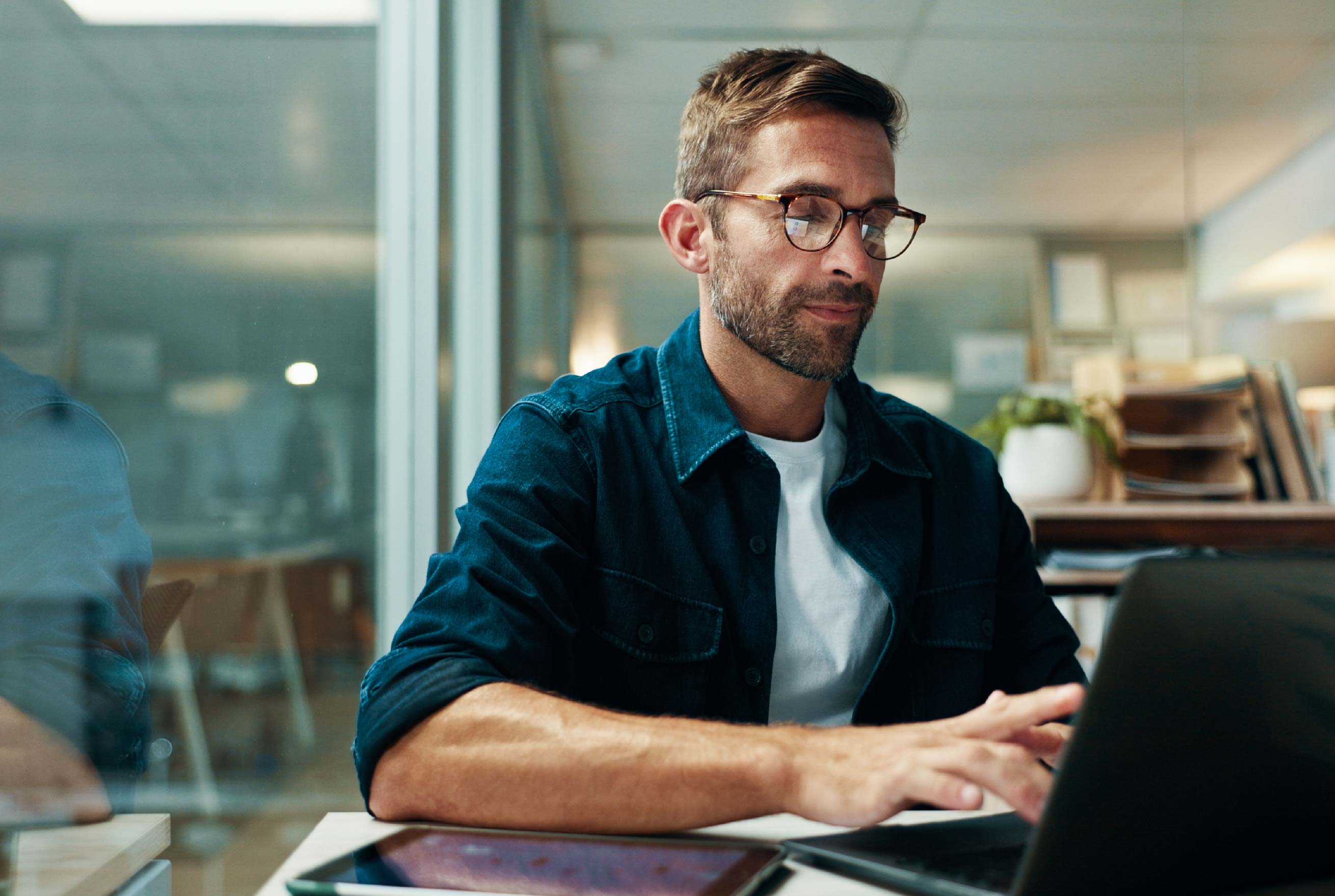Professional working on a laptop in a modern office.