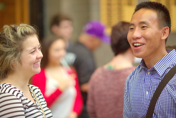 a man and woman smile as they talk