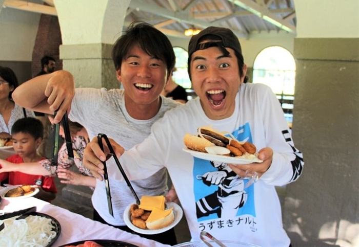 students smile at the camera while enjoying free food