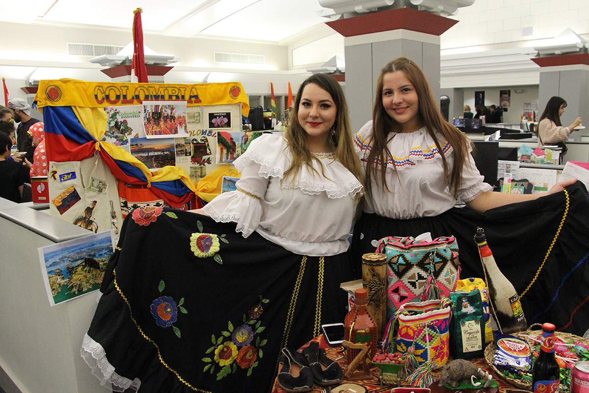 Two international students from Colombia pose by their table at Cafe Internationale