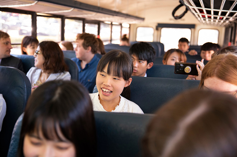 Japanese students ride on a school bus to tour event.