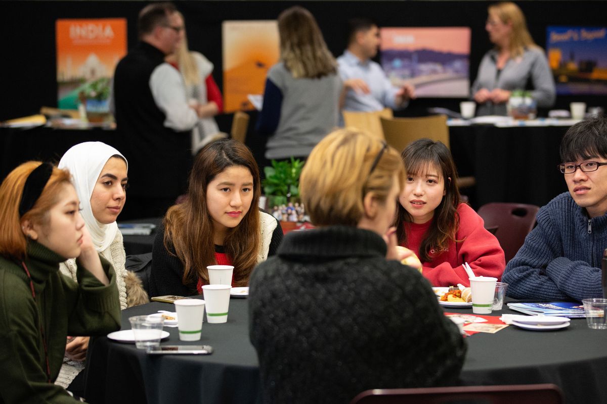 ILUNO Students sit around a table