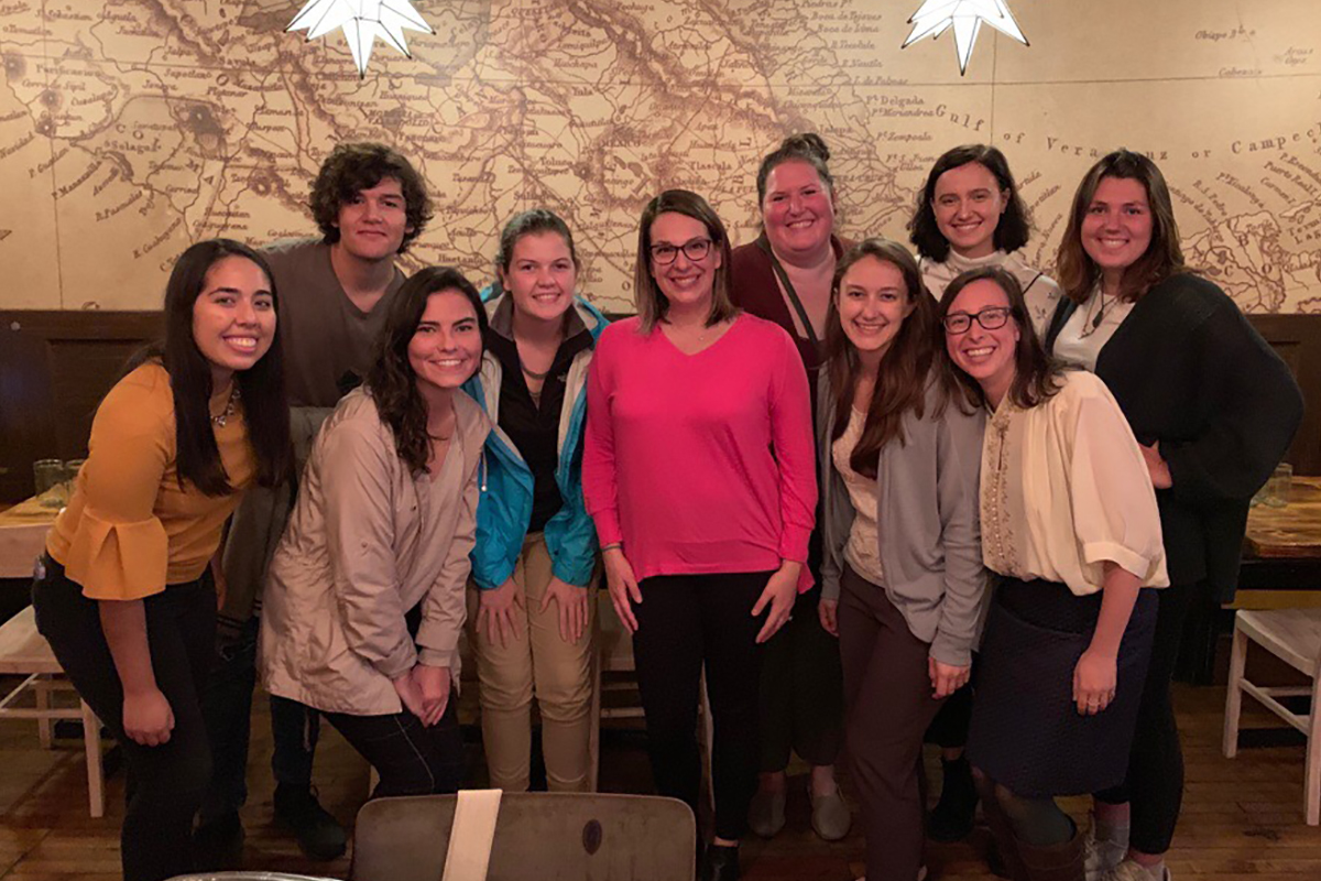 A group of UNO Education Abroad staff poses for a photo in a restaurant with a large map of Mexico on the wall behind them