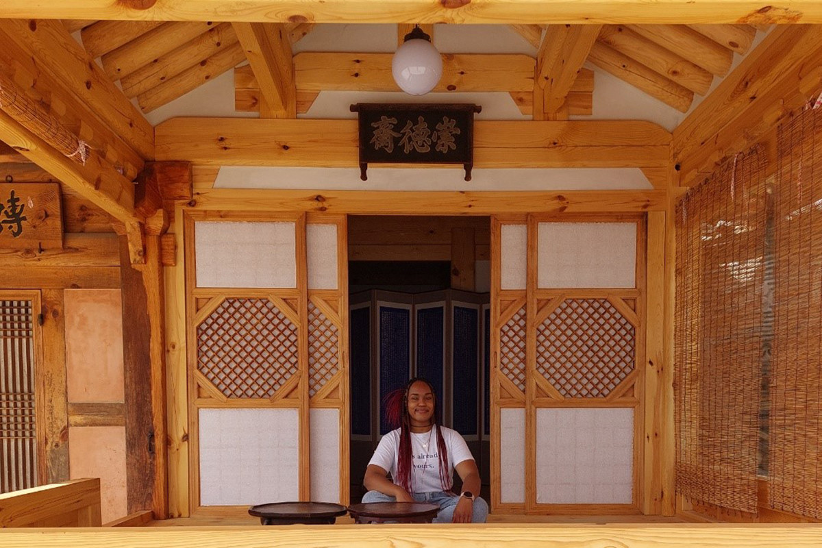 Alexia sits cross-legged in a wooden building in South Korea