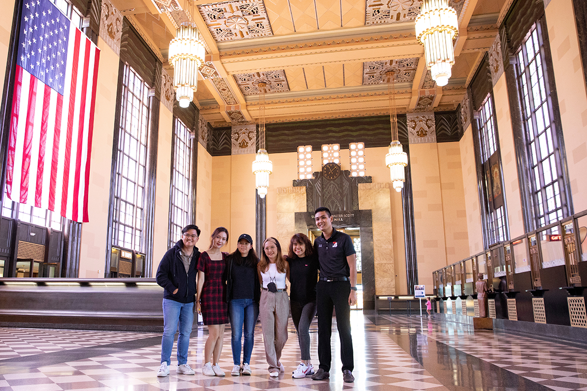 YSEALI students pose in the Durham museum atrium, with a U.S. Flag flying to the left.