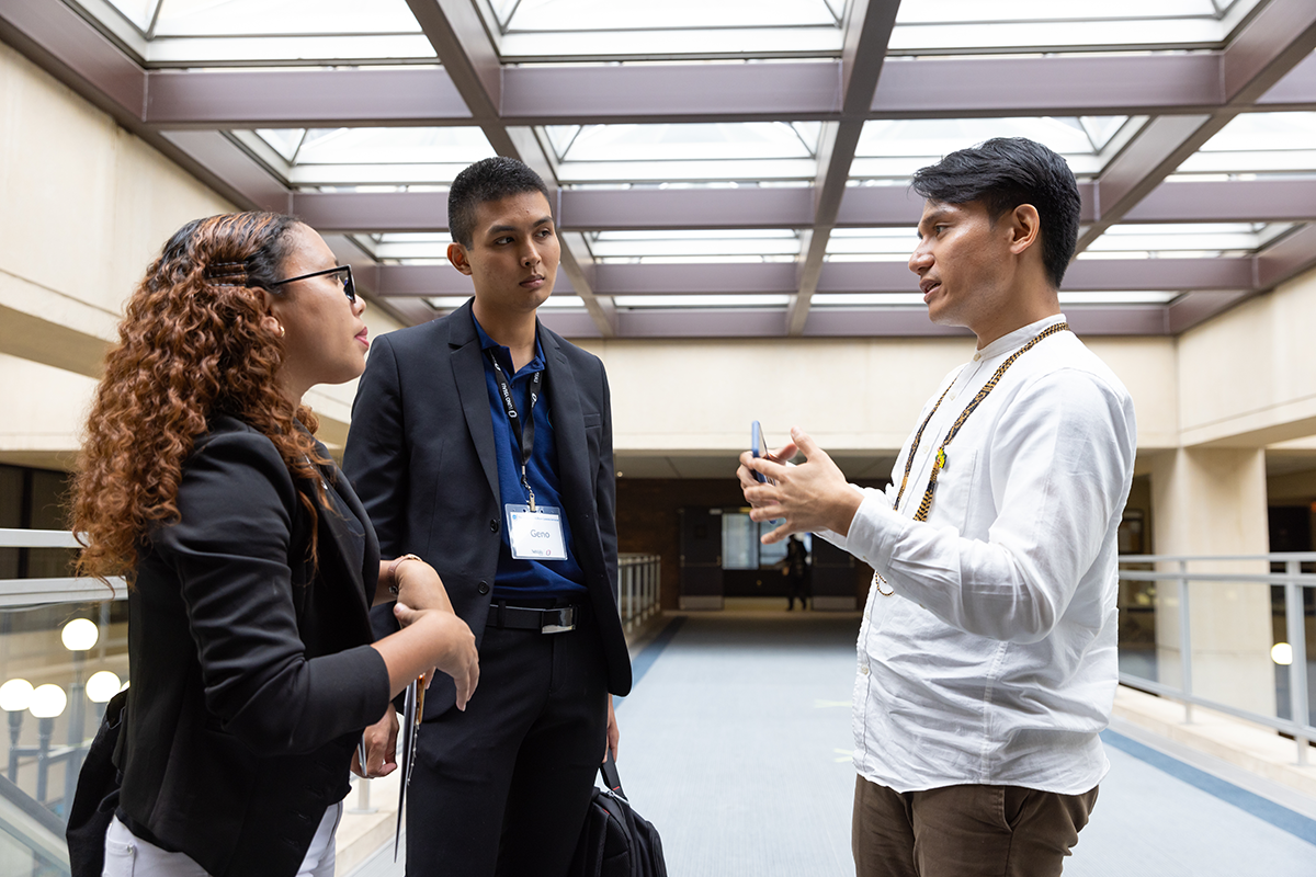 The young professionals stand together in conversation.