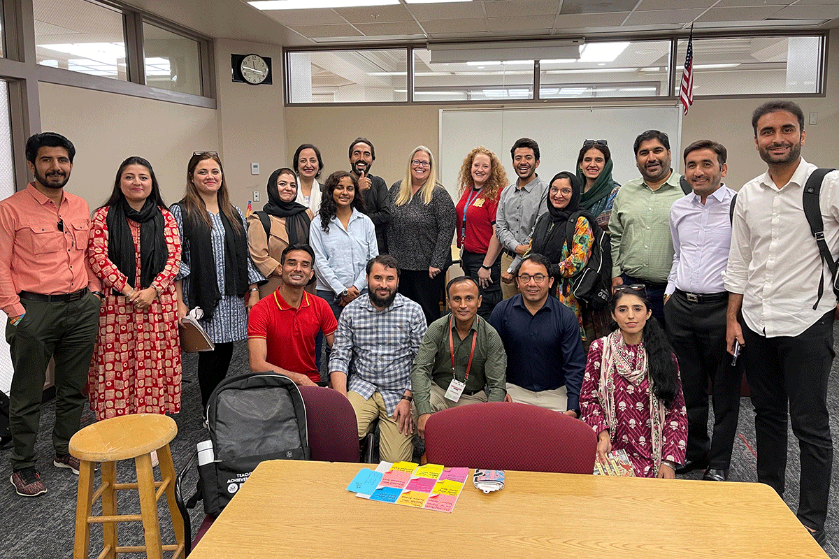 Teachers stand together in a classroom.