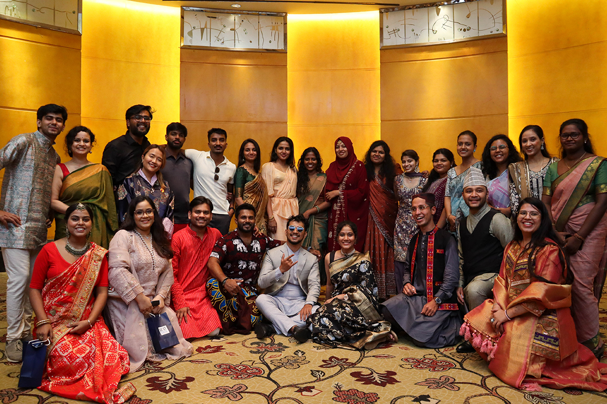 A group of people pose for a photo in their traditional clothing.